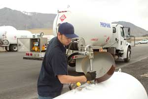 Propane technician pumping fuel into a tank