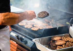 Burgers cooking on a barbecue.