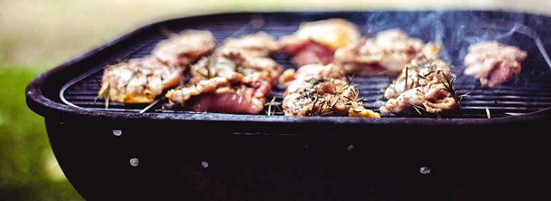 Chicken on a portable barbecue grill.